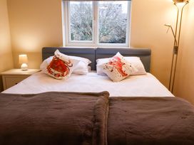 A bedroom with a bed and lamp at Cliff Cottage