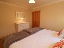 A bedroom with a bed and dressing table at Cliff Cottage