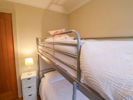 A bunk bed and lamp in a bedroom at Cliff Cottage