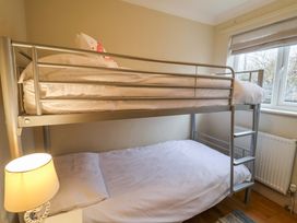 A bedroom with a bunk bed and a window at Cliff Cottage