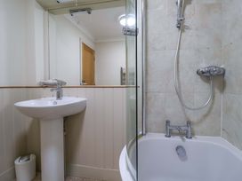 A bathroom with a sink, shower, and bathtub at Cliff Cottage