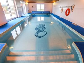 An indoor pool with tile floor and life rings at Cliff Cottage