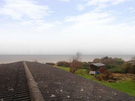 A view of the sea with a shed and grass at Cliff Cottage