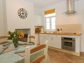 A kitchen with a table and chairs at 8 Railway Cottages in Ulverston