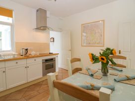 A kitchen with a table and flowers at 8 Railway Cottages in Ulverston