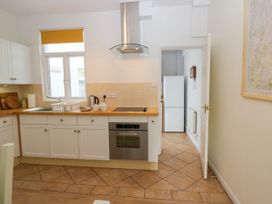 A kitchen with cabinets and a refrigerator at 8 Railway Cottages Ulverston