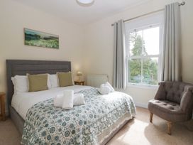 A bedroom with a double bed and an armchair at 8 Railway Cottages in Ulverston