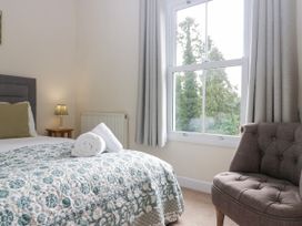 A bedroom with a bed and chair at 8 Railway Cottages in Ulverston