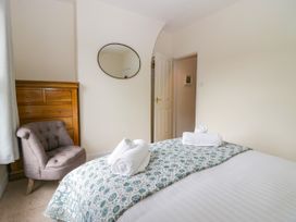 A bedroom with a bed and a chair at 8 Railway Cottages Ulverston