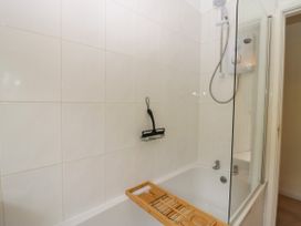 A bathroom with a bathtub and shower head at 8 Railway Cottages Ulverston