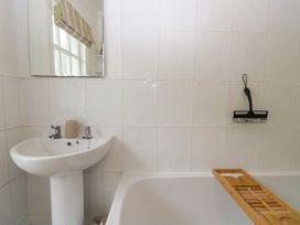 A bathroom with a washbasin and bathtub at 8 Railway Cottages in Ulverston