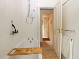 A bathroom with a bathtub and shower controls at 8 Railway Cottages in Ulverston