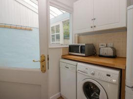A utility room with a washing machine and a microwave at 8 Railway Cottages in Ulverston