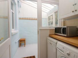A utility room with a washing machine and microwave at 8 Railway Cottages Ulverston