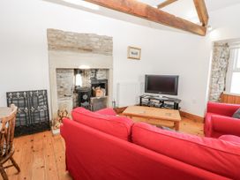 A living room with a fireplace and television at Dove Cottage in Hexham