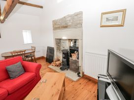 A living room with a fireplace and seating area at Dove Cottage in Hexham