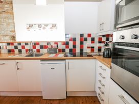 A kitchen with cabinets and appliances at Dove Cottage Hexham