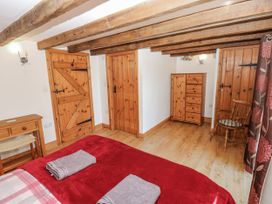 A bedroom with a bed and wooden furniture at Dove Cottage in Hexham