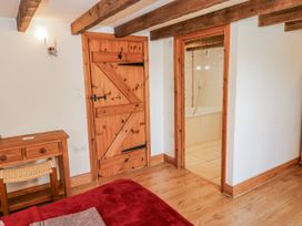 A bedroom with a wooden desk and door at Dove Cottage in Hexham