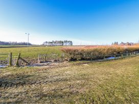 A field with a wind turbine and fence at Dove Cottage in Hexham
