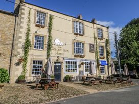 An outdoor patio with tables and umbrellas at The Golden Lion Hotel in Hexham