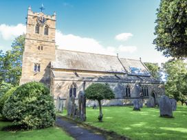 A church with a clock tower and graveyard at Dove Cottage in Hexham