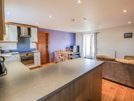 A kitchen and living room with an oven and dining table at Swallows Rest in Hexham