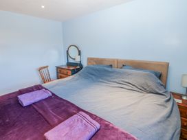 A bedroom with a bed and mirror at Swallows Rest Hexham