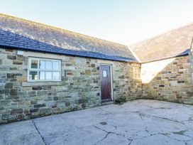An outdoor area with stone walls and a door at Swallows Rest in Hexham