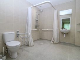 A bathroom with a shower, sink, and toilet at Orme View in Penmaenmawr
