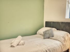 A bed with pillows and towels in a bedroom at 20 Bridge Street in Morpeth