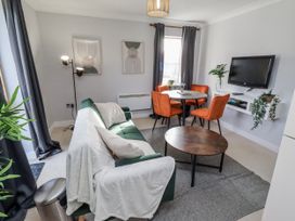 A living room with a sofa and dining table at 16 The Viking in Seahouses