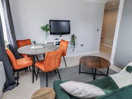 A living room with a table and chairs at 16 The Viking in Seahouses