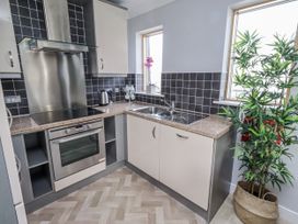 A kitchen with cabinets and appliances at 16 The Viking Seahouses