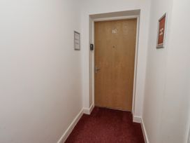 A hallway with a door marked 16 and signs at 16 The Viking Seahouses