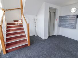 An entrance hall with stairs and mailboxes at 16 The Viking in Seahouses