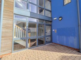 An entrance area with a glass door and stairs at 16 The Viking Seahouses