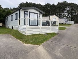 A static caravan with a deck and chairs at WW15 Plot in Newquay