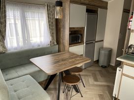 A kitchen with a table and benches at WW15 Plot in Newquay