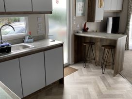 A kitchen with a sink and a bar counter at WW15 Plot Newquay