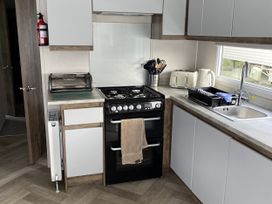 A kitchen with a gas stove and sink at WW15 Plot in Newquay