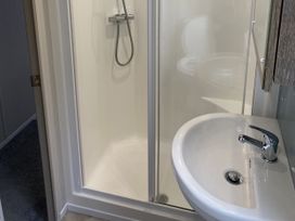 A bathroom with a shower and sink at WW15 Plot in Newquay