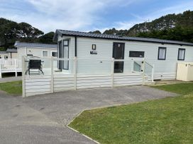 A mobile home with a deck and chair at WW15 Plot Newquay