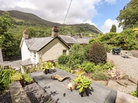 A garden view with a table and plants at Llys Elen in Caernarfon