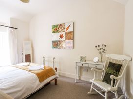 A bedroom with a bed and a chair at Llys Elen in Caernarfon