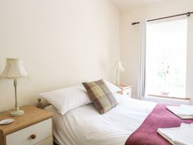 A bedroom with a bed and lamp at Llys Elen in Caernarfon