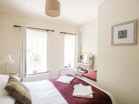 A bedroom with a bed and a mirror at Llys Elen in Caernarfon