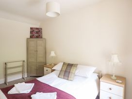 A bedroom with a bed, wardrobe, and bedside table at Llys Elen in Caernarfon