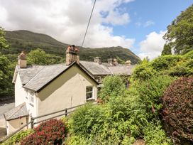 A house with a garden and mountains in the background at Llys Elen in Caernarfon