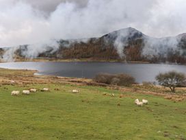 A landscape with sheep by a lake and mountains at Llys Elen in Caernarfon